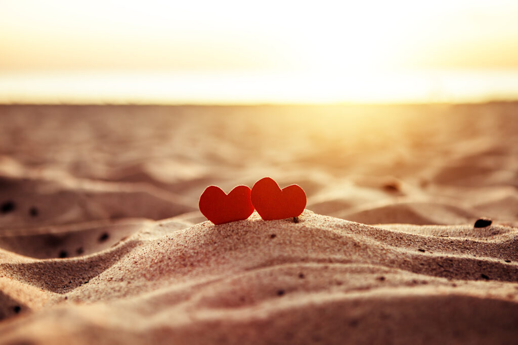 Romantic image of hearts on the beach, symbolizing partnership, trust, and intentional relationship design through premarital therapy