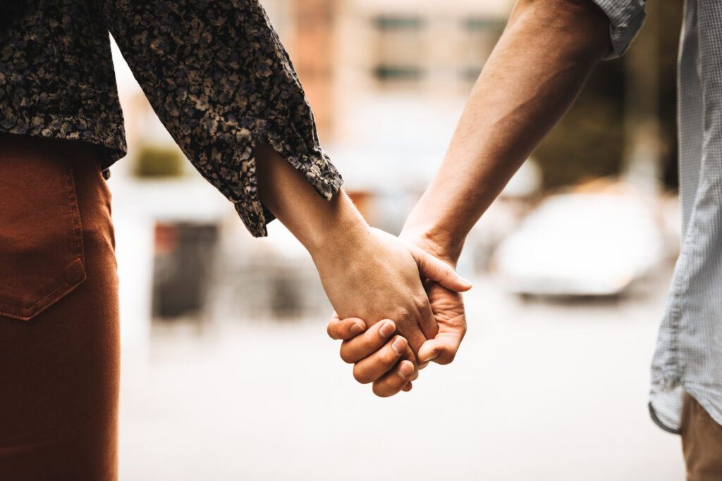 Close-up of a couple holding hands, symbolizing healing, connection, and teamwork through couples relationship therapy