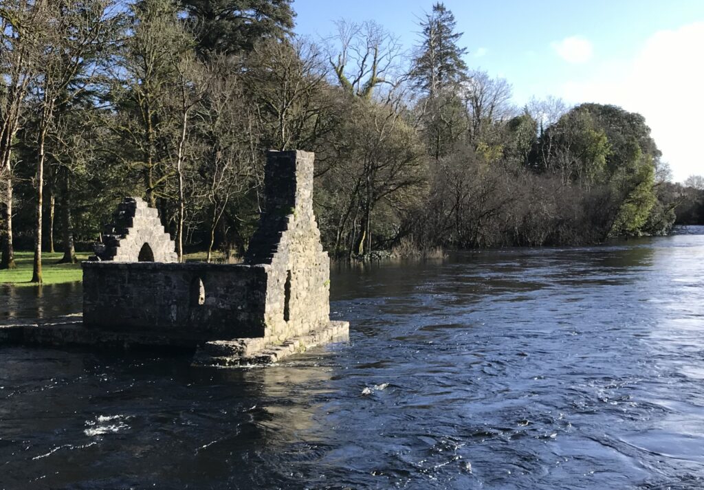 Ancient stone ruins on a peaceful river in the West of Ireland, highlighting the serene and culturally rich setting of couples relationship therapy retreats