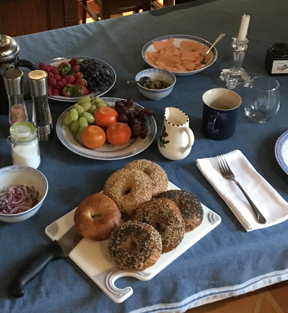 A beautifully set breakfast table with fresh bagels, smoked salmon, seasonal fruits, capers, and coffee, served at a Therapy Intensive retreat in Ireland
