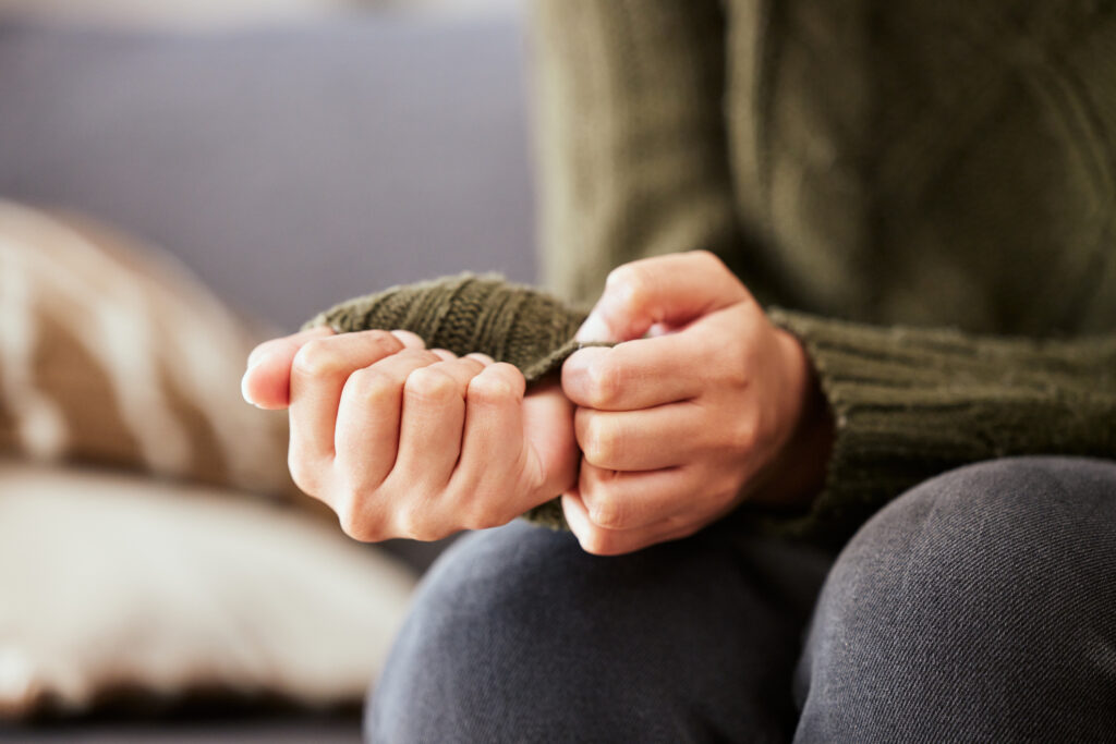 Close-up of person clenching hands in anxiety, illustrating individual therapy support for anxiety, worry, self-doubt, and emotional overwhelm